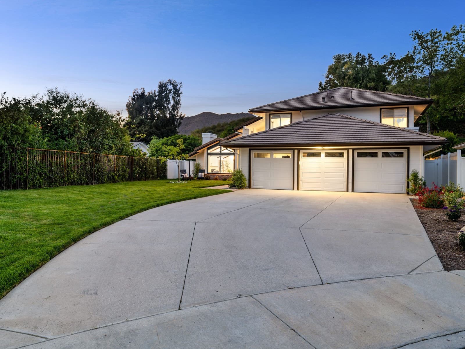 Two-story house, three-car garage at dusk.